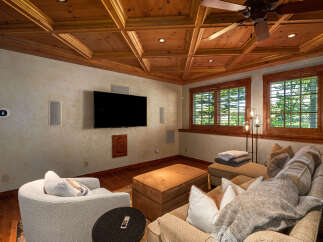Experience ultimate relaxation in this cozy media room, featuring a large sectional sofa, plush armchair, and a convenient ottoman.