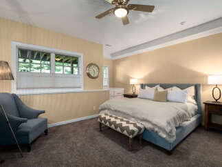Discover comfort and style in this inviting bedroom, featuring a plush king-size bed adorned with crisp white linens and accent pillows.