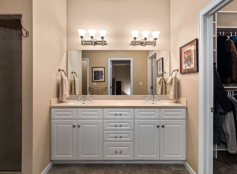 This spacious bathroom features a double vanity with ample storage and elegant fixtures, perfect for a busy household.
