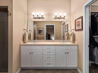 This spacious bathroom features a double vanity with ample storage and elegant fixtures, perfect for a busy household.
