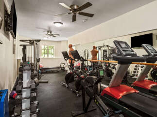 Elevate your fitness routine in this fully equipped home gym, featuring state-of-the-art treadmills, stationary bikes, and a rowing machine.