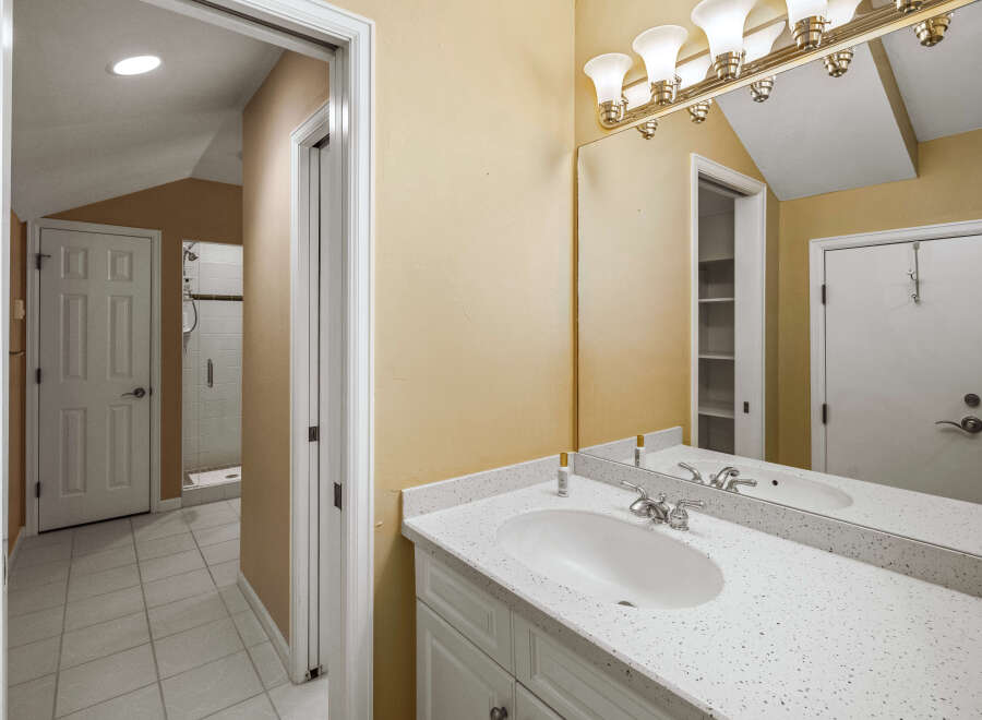 This bathroom features a spacious vanity with a speckled countertop and a modern undermount sink, complemented by a polished chrome faucet.