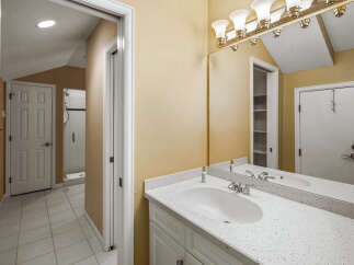 This bathroom features a spacious vanity with a speckled countertop and a modern undermount sink, complemented by a polished chrome faucet.