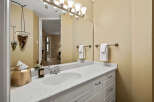 This bathroom features a white vanity with a speckled countertop and a modern sink.