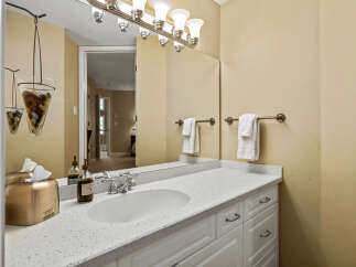This bathroom features a white vanity with a speckled countertop and a modern sink.