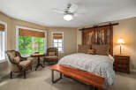 Experience rustic charm in this inviting bedroom, featuring a unique barn door headboard and a cozy seating area by the bay window.