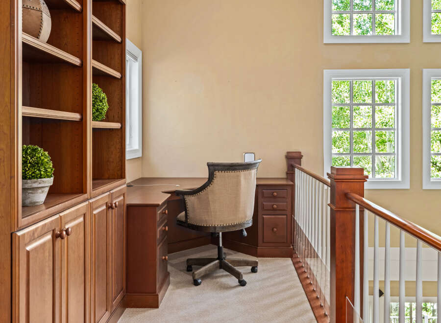 This home office space features a built-in wooden bookshelf and desk, perfect for organization and productivity.
