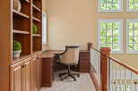 This home office space features a built-in wooden bookshelf and desk, perfect for organization and productivity.