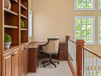 This home office space features a built-in wooden bookshelf and desk, perfect for organization and productivity.