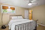 Discover comfort and style in this inviting bedroom, featuring a sleek metal-frame bed adorned with crisp white linens and decorative pillows.