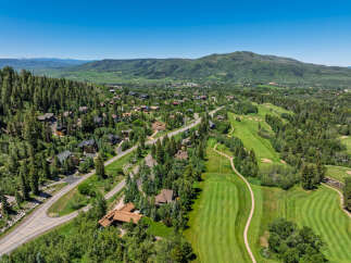 Experience luxury mountain living in this stunning property nestled amidst a picturesque golf course and lush evergreen forests.