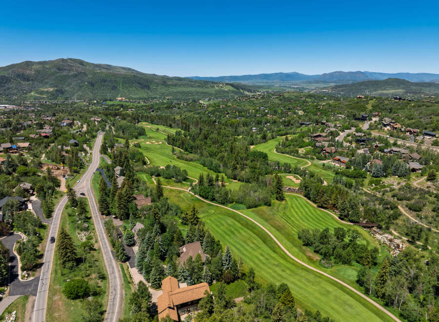 Experience luxury living nestled amidst a picturesque golf course and lush mountain scenery.