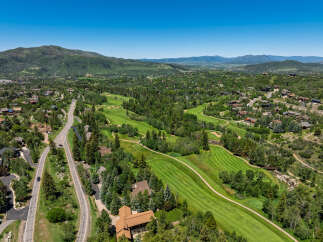 Experience luxury living nestled amidst a picturesque golf course and lush mountain scenery.