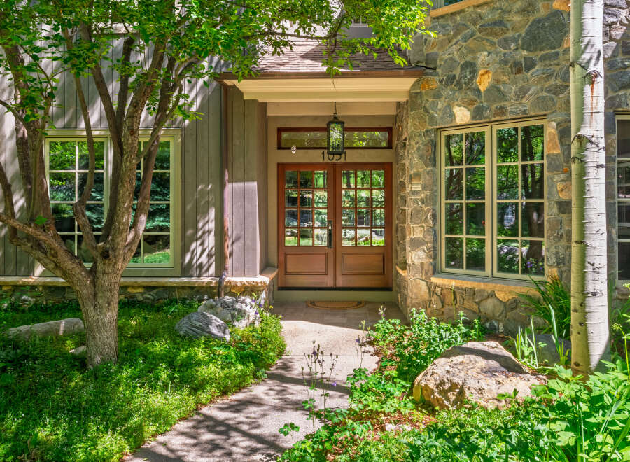 Experience the charm of this mountain home featuring a welcoming entrance with double wooden doors and a classic lantern.