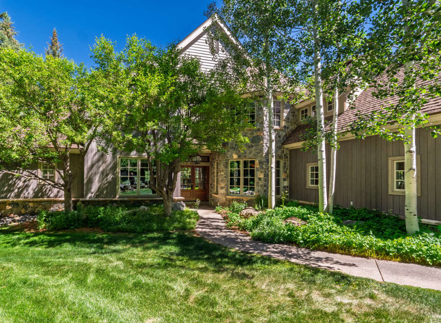 This charming mountain home features a rustic stone and wood exterior, perfect for a serene getaway.