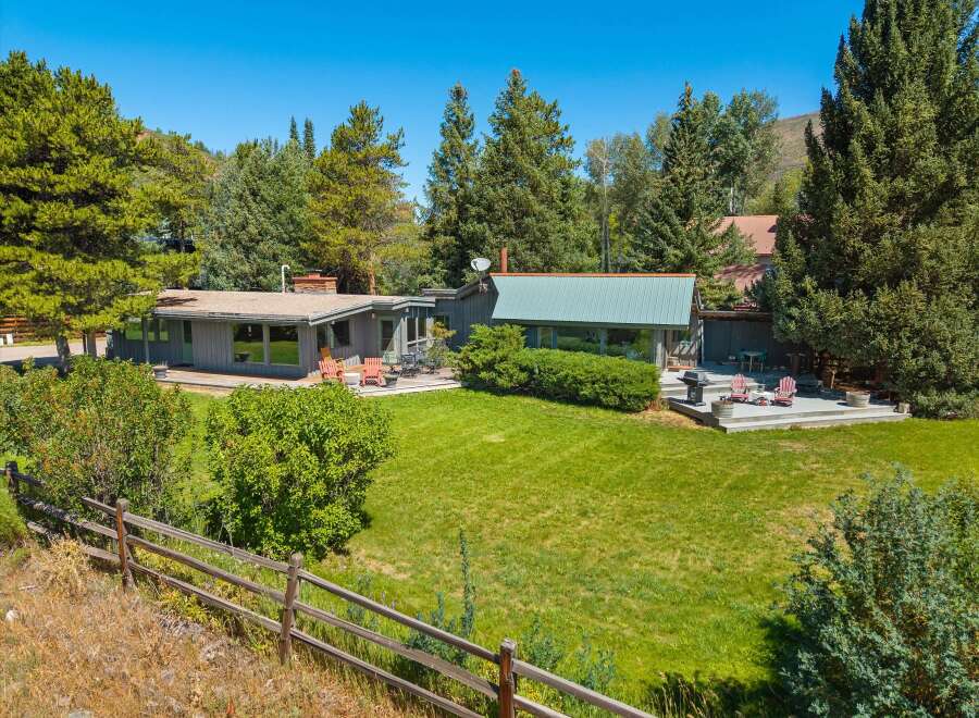 Nestled amidst lush greenery and mature trees, this property offers a serene retreat with ample outdoor living space.