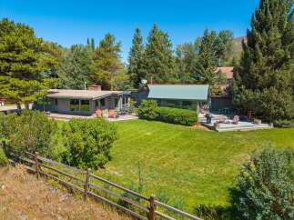 Nestled amidst lush greenery and mature trees, this property offers a serene retreat with ample outdoor living space.