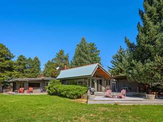 Experience serene living in this charming property featuring a main house and a guest house, both nestled amidst mature trees.