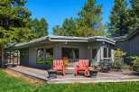 Enjoy outdoor living on this expansive wooden deck, perfect for entertaining or relaxing amidst mature trees.