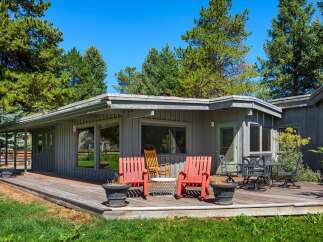 Enjoy outdoor living on this expansive wooden deck, perfect for entertaining or relaxing amidst mature trees.
