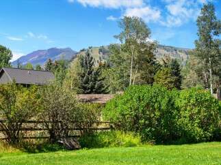 Nestled amidst lush greenery and mature trees, this property offers a serene mountain retreat.