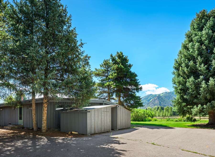 Nestled amidst mature evergreen trees, this property offers a serene mountain retreat.