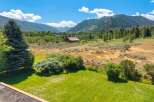 Experience breathtaking mountain views from this stunning property, featuring a picturesque barn and lush green lawns perfect for outdoor enjoyment.