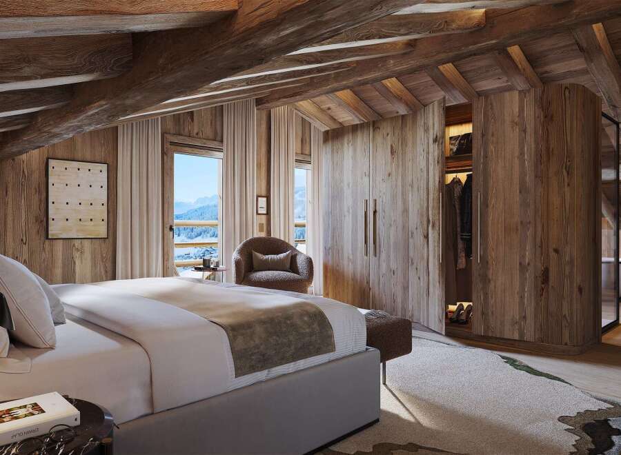 Experience luxurious mountain living in this stunning chalet bedroom, featuring exposed wooden beams and panoramic windows showcasing breathtaking snowy vistas.