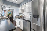 Discover this modern kitchen featuring sleek white cabinetry, a stylish subway tile backsplash, and a durable dark countertop.