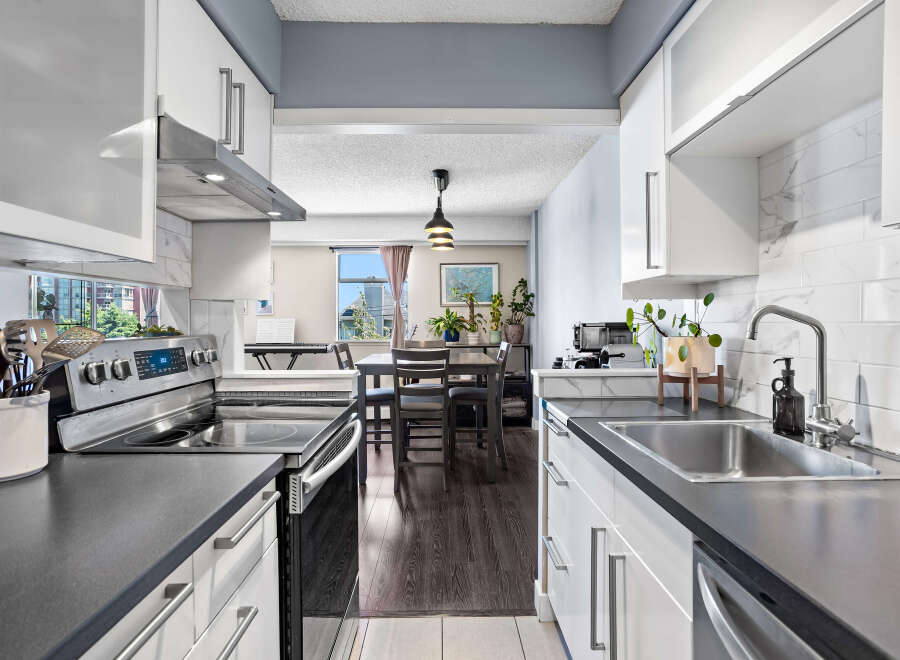 Discover this modern kitchen featuring sleek white cabinetry and a stylish marble backsplash.