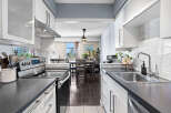 Discover this modern kitchen featuring sleek white cabinetry and a stylish marble backsplash.