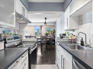 Discover this modern kitchen featuring sleek white cabinetry and a stylish marble backsplash.