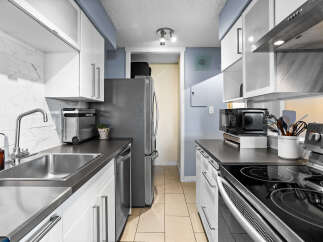 Discover this modern kitchen featuring sleek white cabinetry and a stylish marble backsplash.