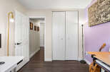 Discover this inviting space featuring a bright white door leading into a hallway with charming framed portraits.