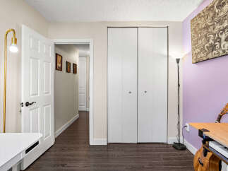 Discover this inviting space featuring a bright white door leading into a hallway with charming framed portraits.