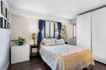 Discover this charming bedroom featuring a comfortable queen-size bed adorned with a floral quilt and crisp white linens.