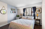 This charming bedroom features a comfortable queen-size bed adorned with a floral quilt, perfect for restful nights.