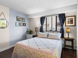 This charming bedroom features a comfortable queen-size bed adorned with a floral quilt, perfect for restful nights.