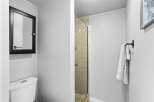 This modern bathroom features a sleek toilet and a stylish medicine cabinet with a black frame.