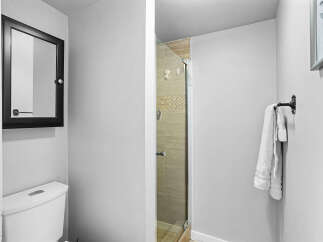 This modern bathroom features a sleek toilet and a stylish medicine cabinet with a black frame.