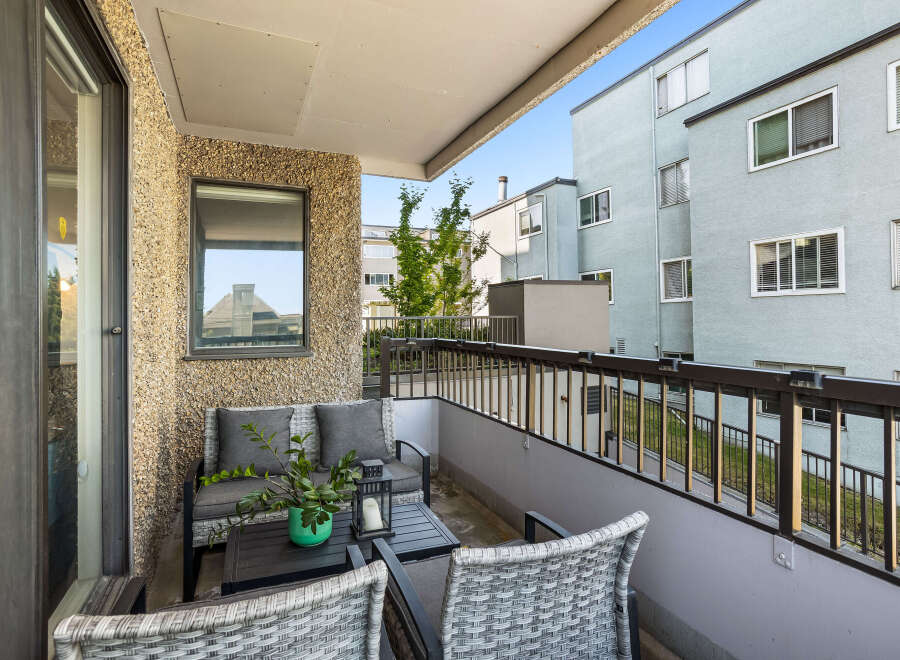 Enjoy your morning coffee on this charming balcony, complete with comfortable seating and a coffee table.