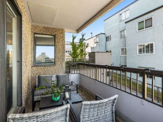 Enjoy your morning coffee on this charming balcony, complete with comfortable seating and a coffee table.