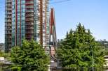 Experience modern urban living in this stunning high-rise apartment, featuring a vibrant red facade and expansive balconies offering city views.