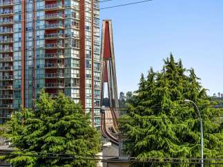 Experience modern urban living in this stunning high-rise apartment, featuring a vibrant red facade and expansive balconies offering city views.