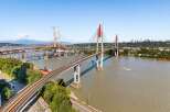 Experience breathtaking views and seamless connectivity with this stunning waterfront property, featuring multiple bridges and a vibrant cityscape in the distance.