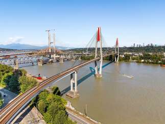 Experience breathtaking views and seamless connectivity with this stunning waterfront property, featuring multiple bridges and a vibrant cityscape in the distance.