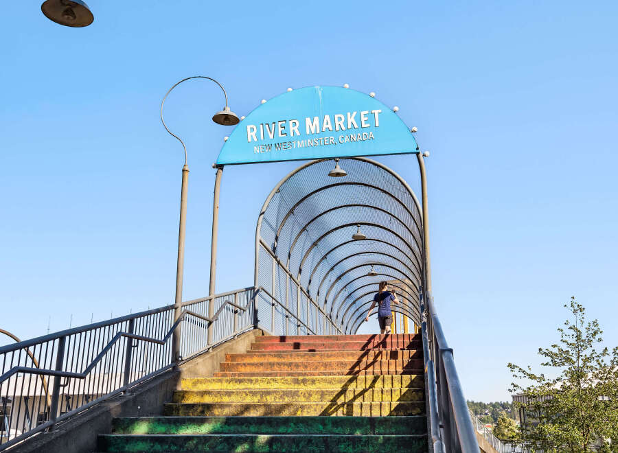 Discover the vibrant River Market in New Westminster, Canada, accessible via a colorful pedestrian bridge.