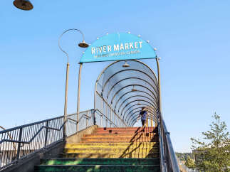 Discover the vibrant River Market in New Westminster, Canada, accessible via a colorful pedestrian bridge.