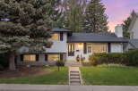 Charming two-story home with a welcoming facade, featuring a well-maintained lawn and mature trees.
