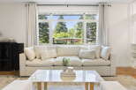 Experience seamless indoor-outdoor living with this spacious living room, featuring a large picture window that floods the space with natural light and offers picturesque views of the surrounding greenery.